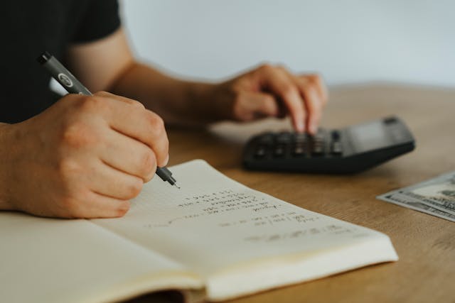 Person-schreibt-weißes-Notizbuch