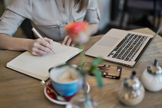 person-writing-white-notebook