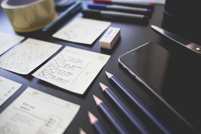 pecils next to papers with ux designs on them