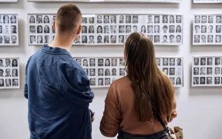 Zwei junge Erwachsene stehen vor Alumni-Fotos und fragen sich, was soll ich studieren