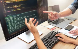 UX designers pointing at a screen to monitor user experience design