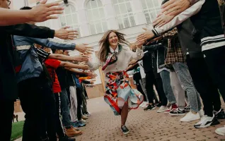 Absolventin freut sich über Bachelor-Abschluss und klatscht Hände ab