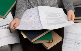 Close-up of a person holding university thesis research papers