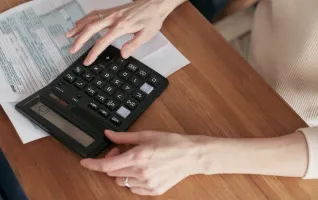 Woman managing finances while using a calculator