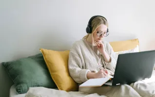 Woman taking notes during a distance learning class