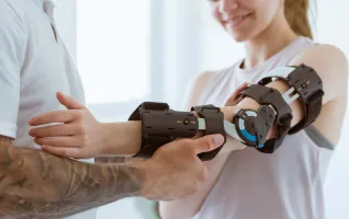 Orthopäde legt eine Orthobionik-Prothese an den Arm einer Patientin an