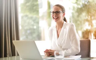 laughing-businesswoman-working-laptop-office