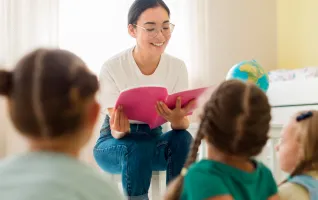 Frontansicht einer Frau die ihren Studenten etwas vorließt