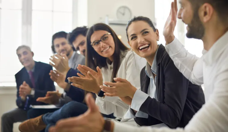 Gruppe klatscht in Wirtschaftspsychologie-Seminar