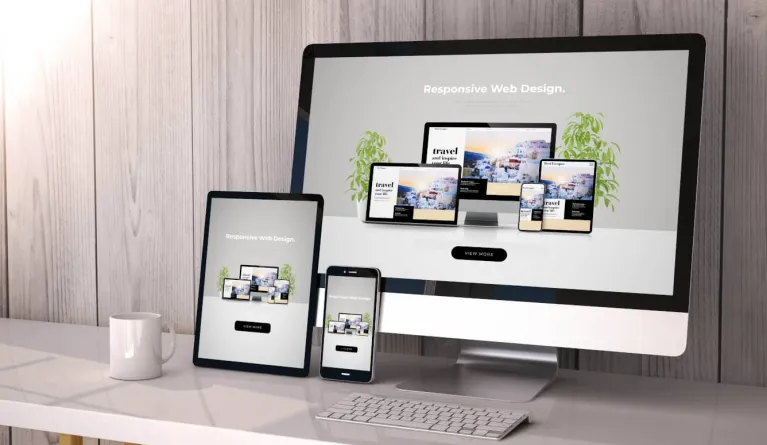 Bildschirme in verschiedenen Größen auf einem Schreibtisch veranschaulichen responsives Webdesign