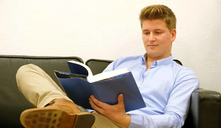 Student reading in a book about reasons to get an MBA degree
