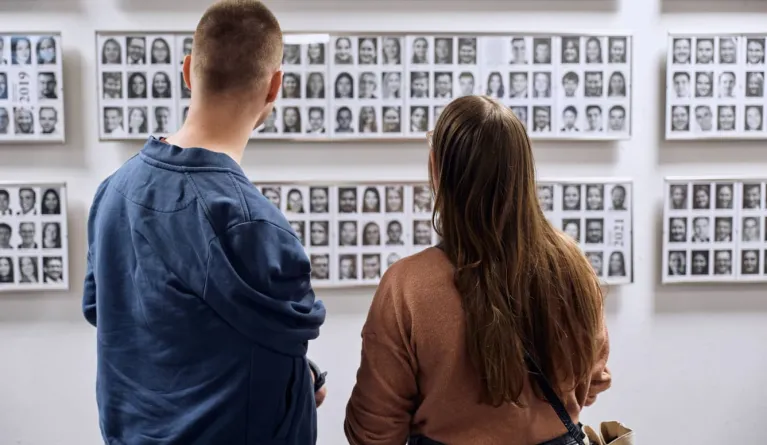 Zwei junge Erwachsene stehen vor Alumni-Fotos und fragen sich, was soll ich studieren