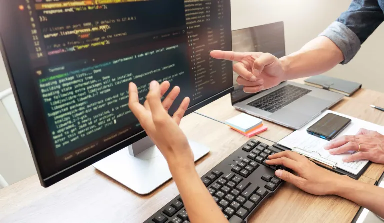 UX designers pointing at a screen to monitor user experience design