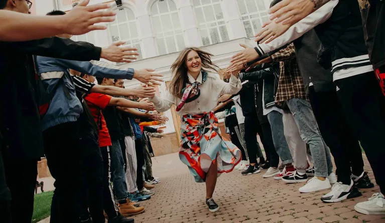 Absolventin freut sich über Bachelor-Abschluss und klatscht Hände ab