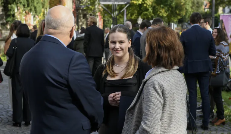 Eine Studieninteressierte steht mit ihren Eltern zusammen.