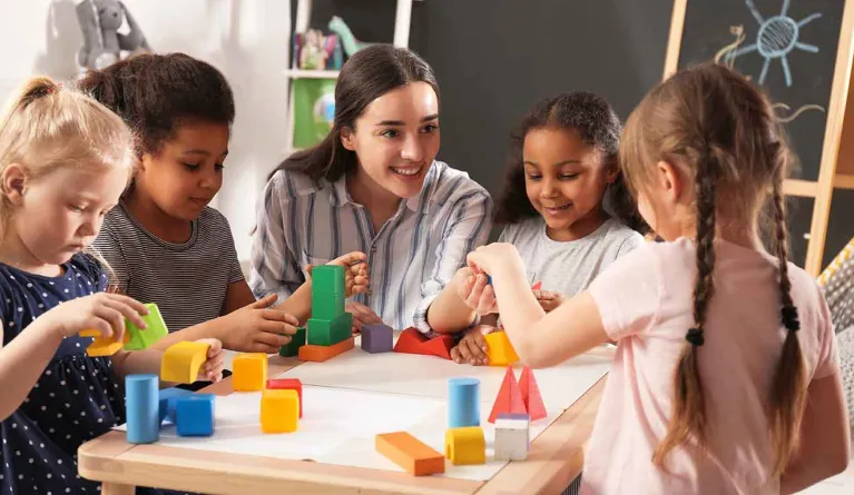 FSJ-Absolventin spielt mit Kindern in der Kita