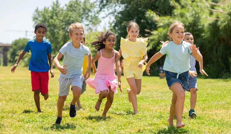 Kinder laufen glücklich und geschützt auf einer Wiese