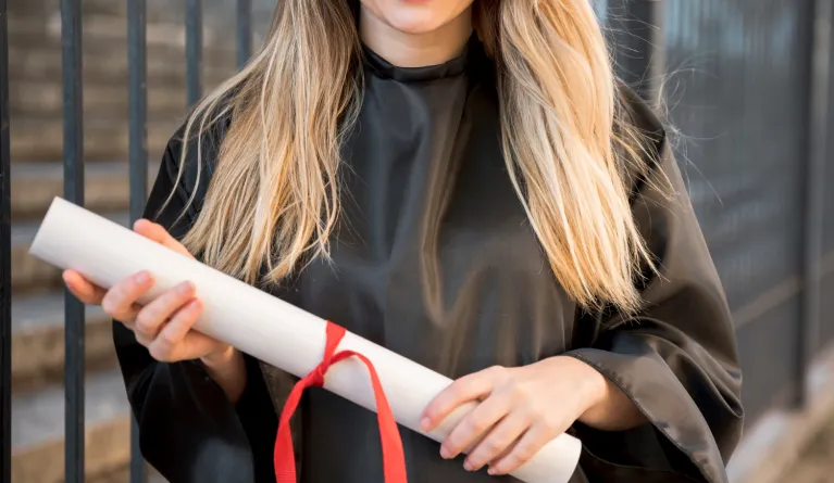 Front view girl smiling holding her master's degree diploma