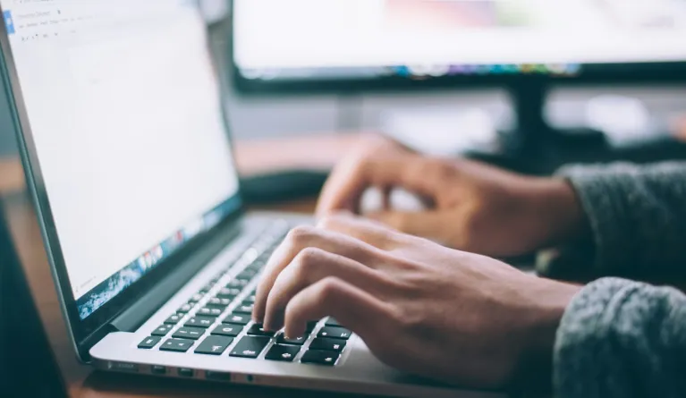 Person, die das MacBook Pro mit digitaler Technologie nutzt