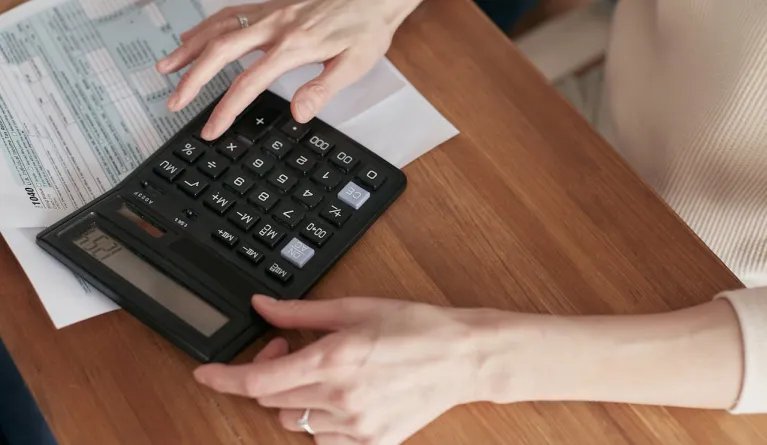 Woman managing finances while using a calculator