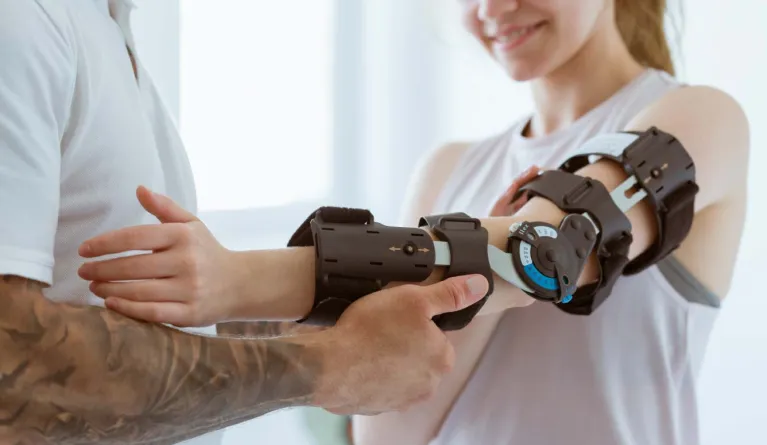 Orthopäde legt eine Orthobionik-Prothese an den Arm einer Patientin an