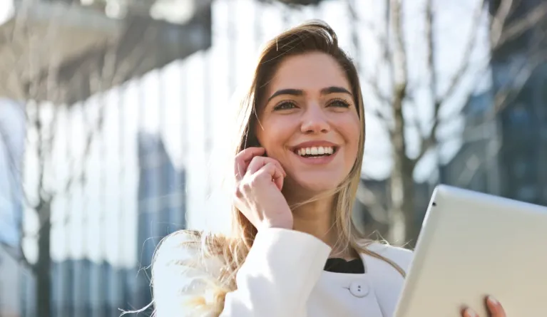 Frau-weißer-Blazer-hält-Tabletcomputer-redet-Telefon