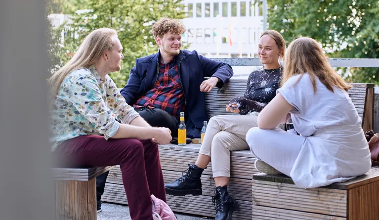 Studierende sitzen am Campus Göttingen.