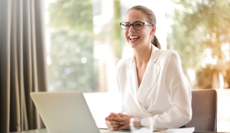 laughing-businesswoman-working-laptop-office
