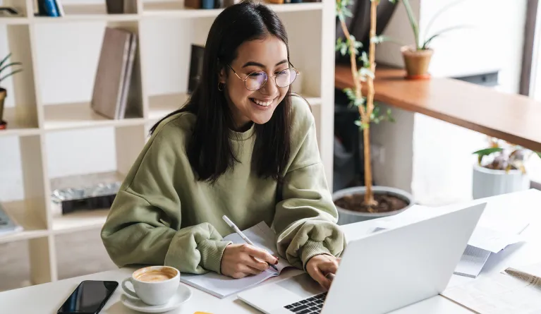 Eine Campusstudentin lernt am Laptop.