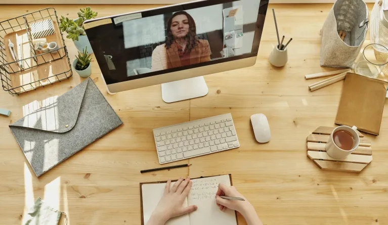 Person, die während des Studiums in ein Notizbuch schreibt