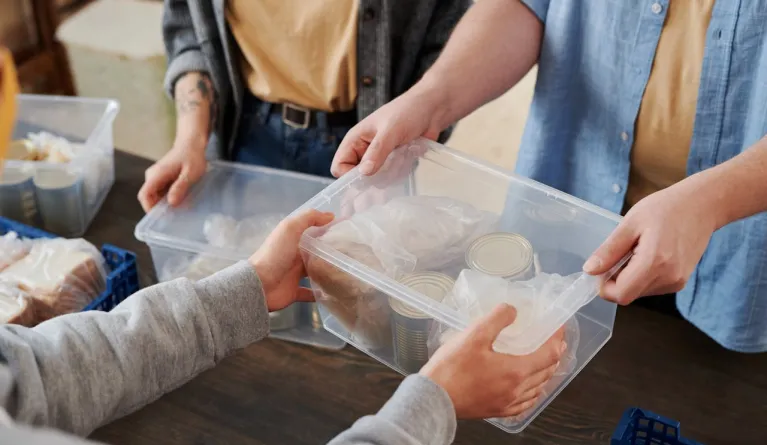 person handing over box with food