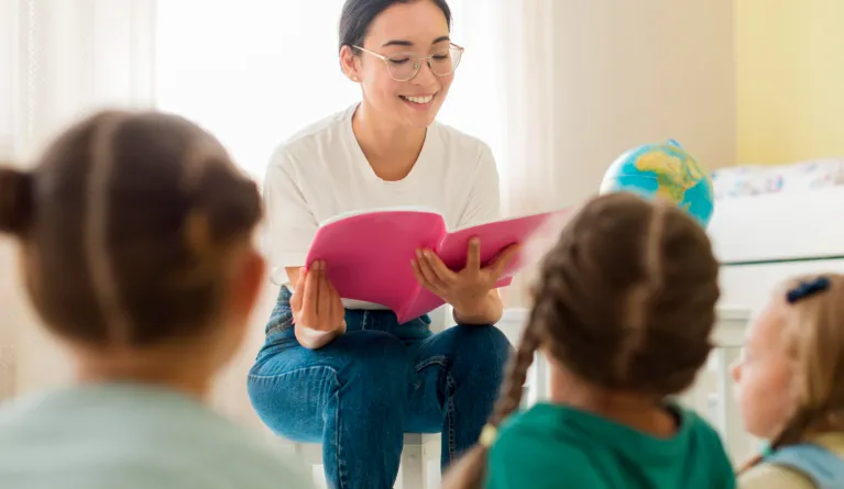 front view of a woman reading something for her students
