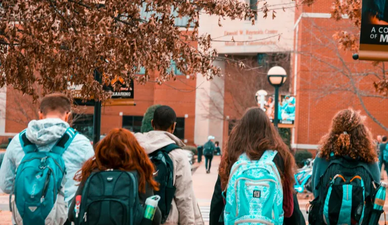 group of students walking towards a private university entrance