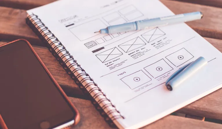 notebook with ux design wireframes