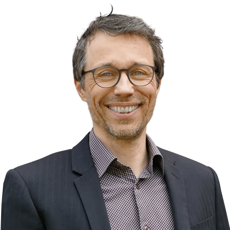 Professor Siebert ist Dozent an der PFH Göttingen und unterrichtet im Digitalization-Automation-Studium an der PFH, er trägt ein kariertes Hemd und einen dunklen Anzug.