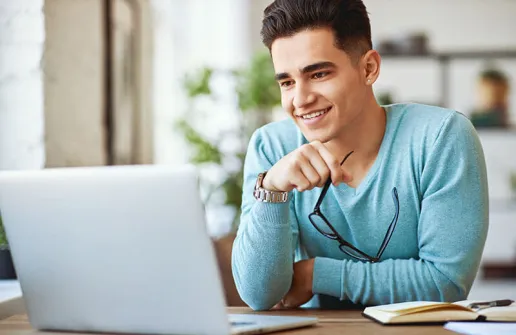 Student sieht sich am Laptop Inhalte des Master UX Design Fernstudium an
