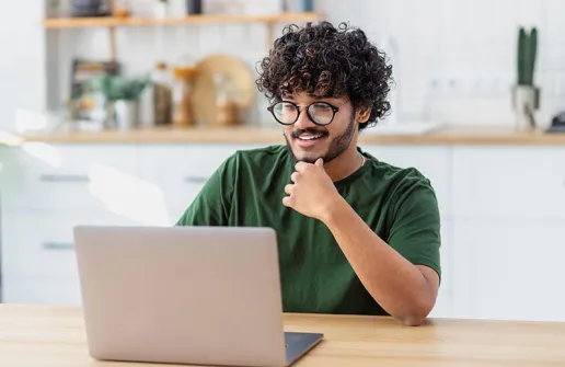 Student sieht sich am Laptop Inhalte des Fernstudienganges Wirtschaftsinformatik im Bachelor Fernstudium an 