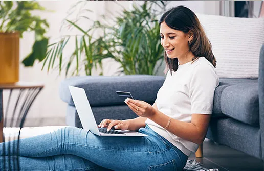 Kindheitspädagogik-Studentin freut sich am Laptop über erfolgreiche Fernstudium-Finanzierung